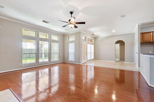 The open concept living room and kitchen is light and bright with a wall of windows looking out to the beautiful backyard | Image 12