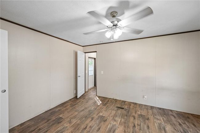 Unfurnished room featuring ornamental molding, wood finished floors, and a ceiling fan | Image 25