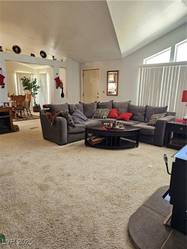 Carpeted living area featuring lofted ceiling and a textured ceiling | Image 10