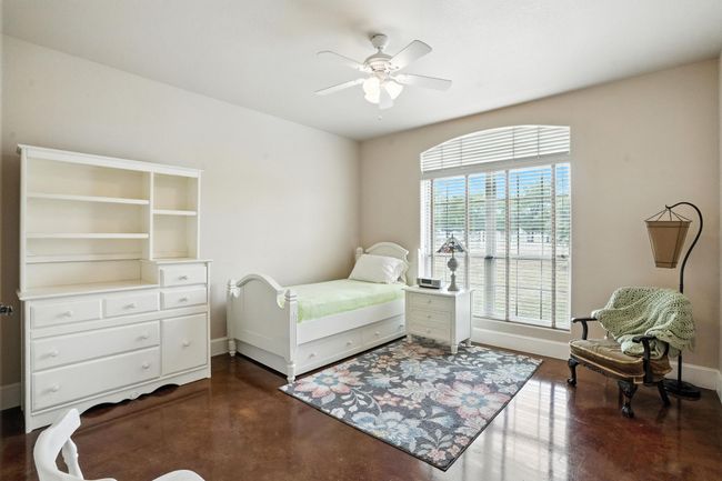 Bedroom featuring finished concrete flooring and a ceiling fan | Image 25