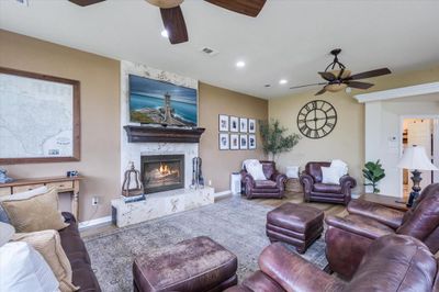 Living room with ceiling fan, a high end fireplace, and hardwood / wood-style floors | Image 2