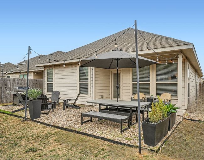 Rear view of house with a patio area, fence, and a shingled roof | Image 26