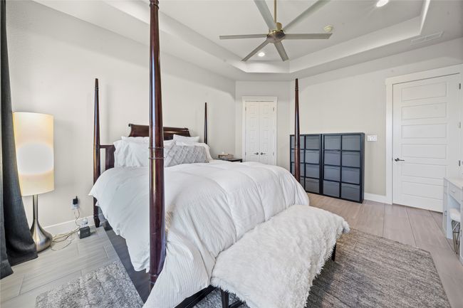 Bedroom featuring recessed lighting, a tray ceiling, a ceiling fan, and wood finish floors | Image 15