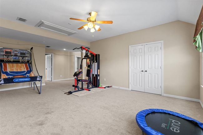 Exercise room featuring ceiling fan, carpet floors, baseboards, and attic access | Image 25
