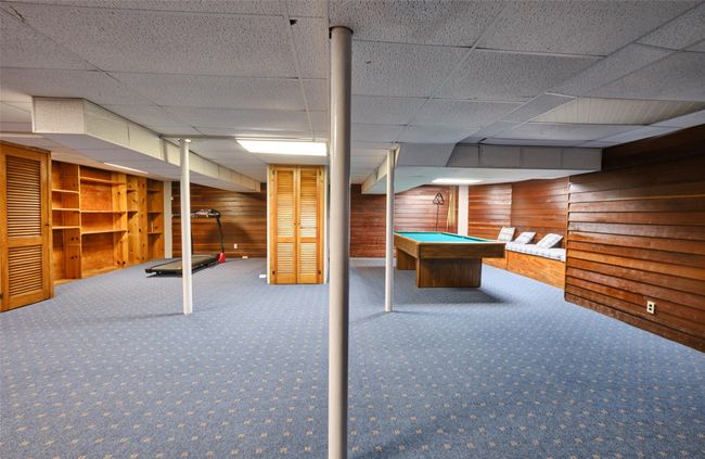 Finished below grade area featuring wood walls, carpet, and pool table | Image 15