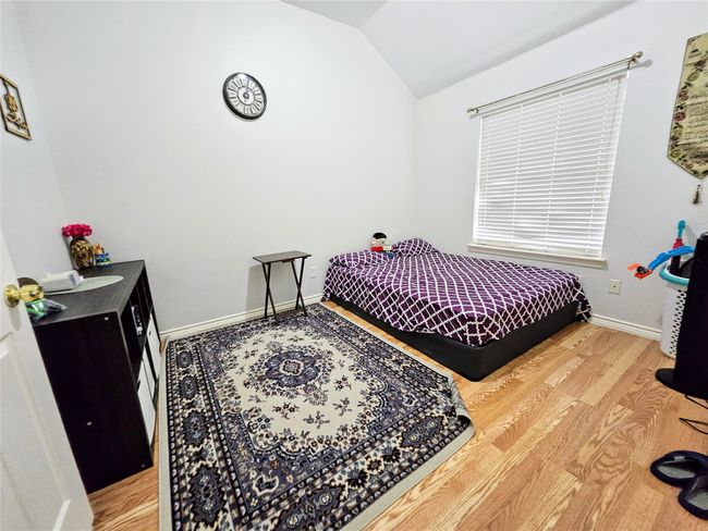 Bedroom with vaulted ceiling and wood finished floors | Image 26