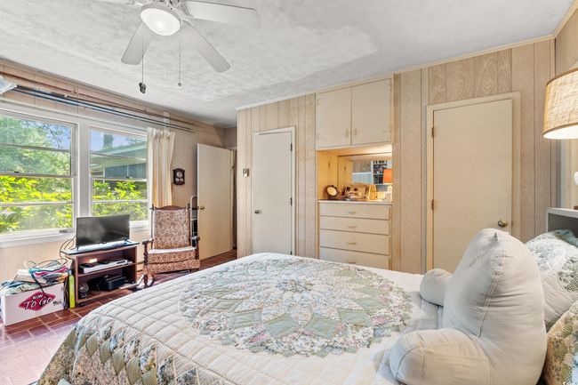 Bedroom with wood walls and a ceiling fan | Image 7