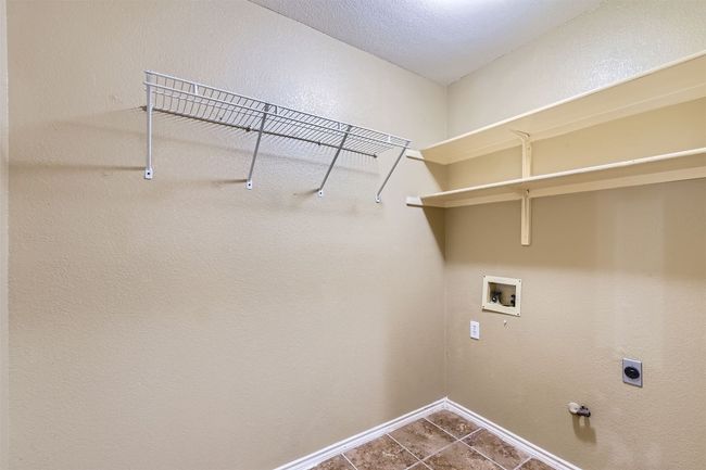 Laundry room with hookup for a washing machine, electric dryer hookup, baseboards, dark tile patterned flooring, and hookup for a gas dryer | Image 21