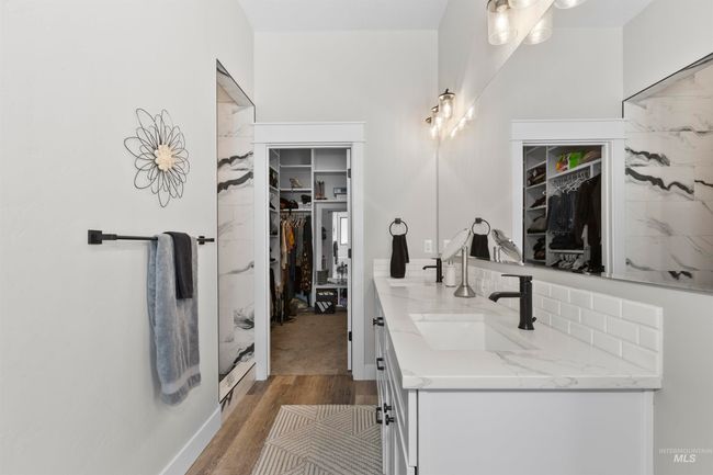 Full bathroom with double vanity, wood finished floors, and a spacious closet | Image 28