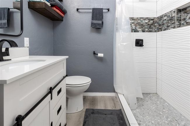 Bathroom featuring toilet, vanity, a shower with curtain, and hardwood / wood-style flooring | Image 16