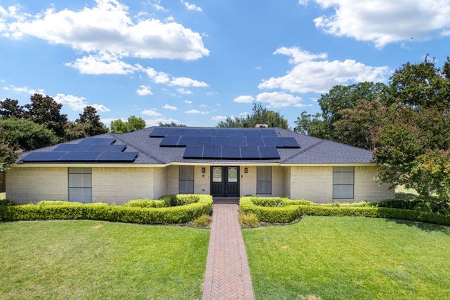 View of front of house with a front yard, roof mounted solar panels, a shingled roof, and brick siding | Image 6