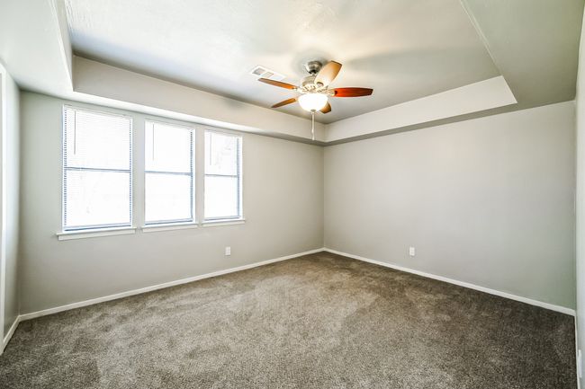 Carpeted spare room with visible vents, baseboards, and a tray ceiling | Image 16