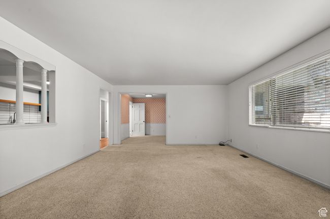 Carpeted empty room featuring decorative columns and baseboards | Image 14
