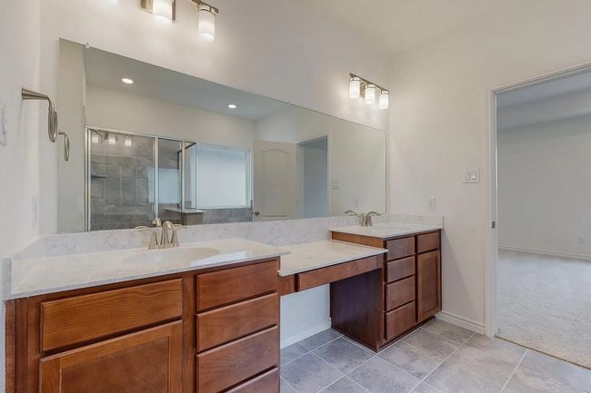 Bathroom featuring double vanity, a shower stall, tile patterned floors, baseboards, and recessed lighting | Image 14