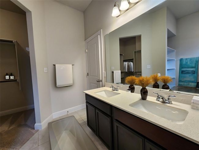 Full bath with double vanity, tile patterned floors, a tub, and a spacious closet | Image 15