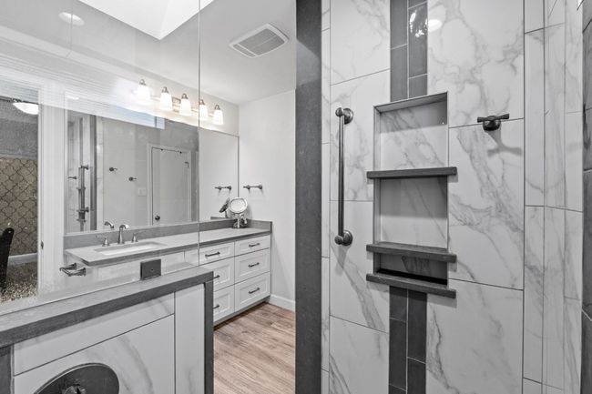 Full bathroom featuring wood finished floors, visible vents, vanity, baseboards, and walk in shower | Image 19