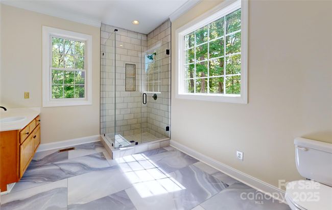 Windows in primary bath welcome natural light. | Image 26