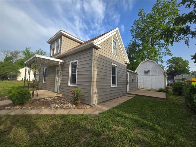 View of property exterior with a patio area, a yard, an outbuilding, and a shed | Image 26