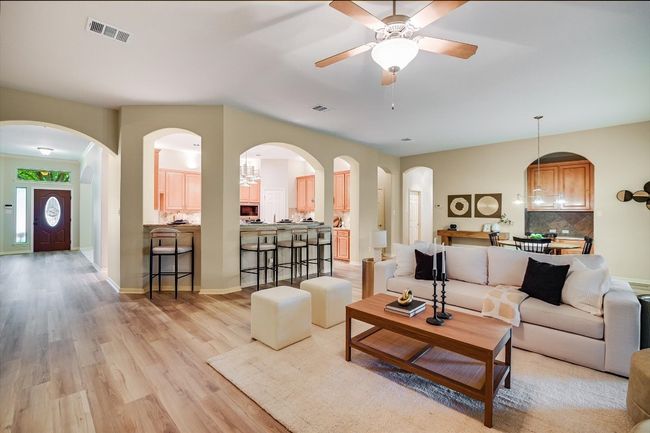Living area featuring light wood finished floors and a ceiling fan | Image 15