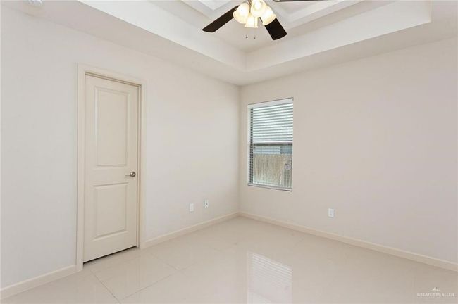 Unfurnished room featuring ceiling fan, a raised ceiling, and light tile patterned flooring | Image 10