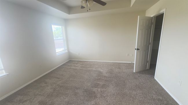 Carpeted spare room with ceiling fan and a raised ceiling | Image 8