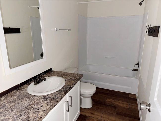 Full bathroom featuring vanity, washtub / shower combination, and wood finished floors | Image 13