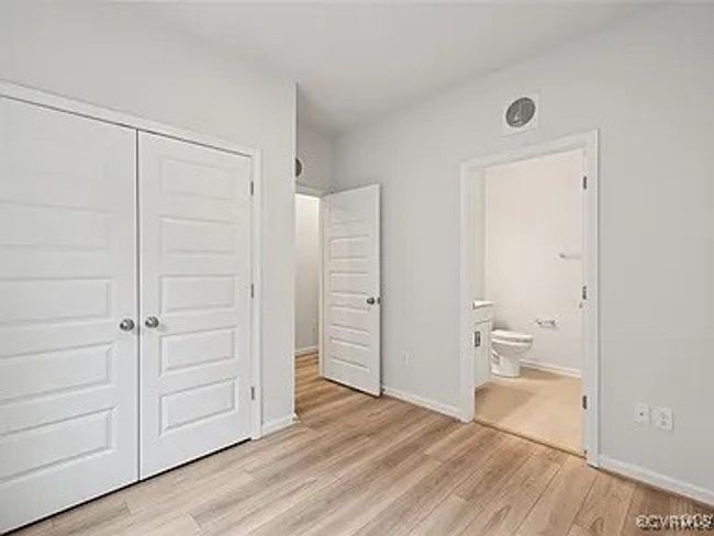 Unfurnished bedroom with light wood-type flooring, a closet, and connected bathroom | Image 29