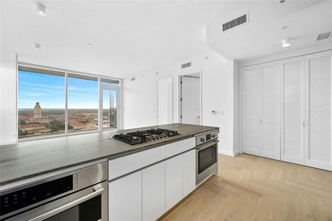 Kitchen featuring stainless steel appliances, white cabinetry, and dark countertops. | Image 6