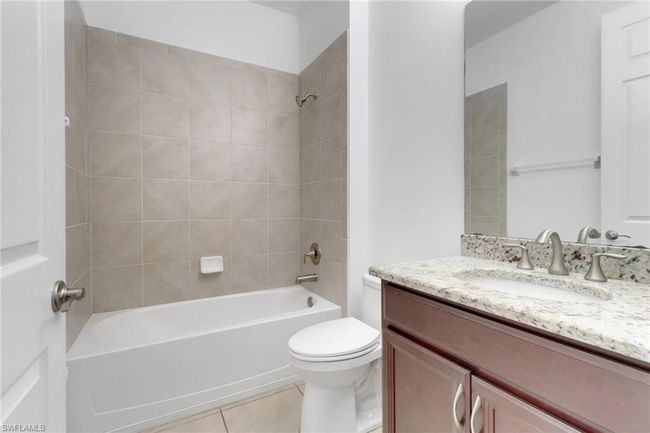 Bathroom featuring toilet, shower / tub combination, tile patterned flooring, and vanity | Image 10