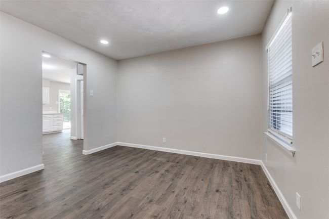 Empty room with dark wood-style floors and recessed lighting | Image 9