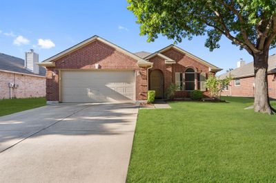 Single story home featuring a front yard and a garage | Image 1