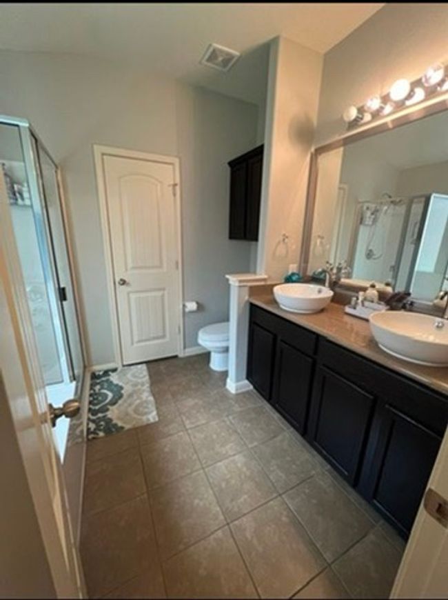 Bathroom with a shower stall, double vanity, and tile patterned floors | Image 11