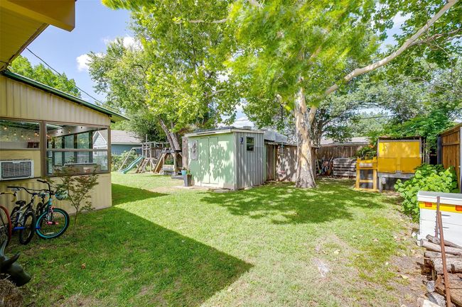 Fenced backyard featuring a playground and a storage unit | Image 32