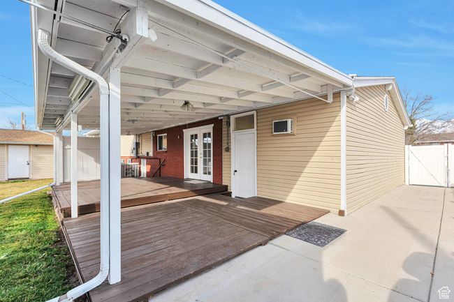 Exterior space featuring a gate, fence, an outdoor structure, french doors, and a storage shed | Image 16