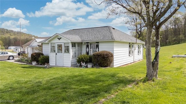 View of home's exterior featuring a yard and a shingled roof | Image 37