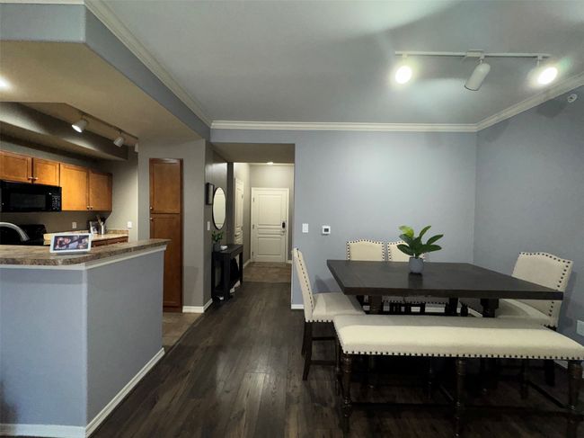 Dining room with dark wood-type flooring and crown molding | Image 9