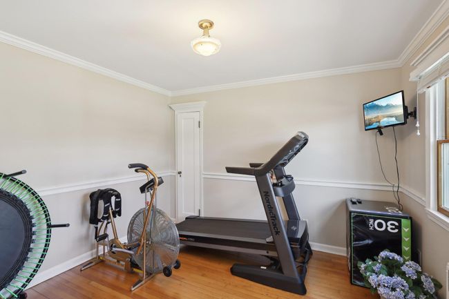 Exercise room with hardwood / wood-style floors, crown molding, and baseboards | Image 26