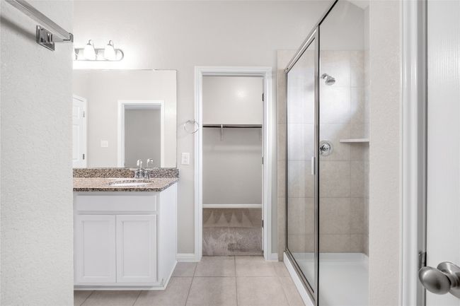 Bathroom featuring tile patterned flooring, a stall shower, vanity, and a spacious closet | Image 25