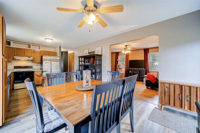 Dining area featuring light wood-type flooring and ceiling fan | Image 12