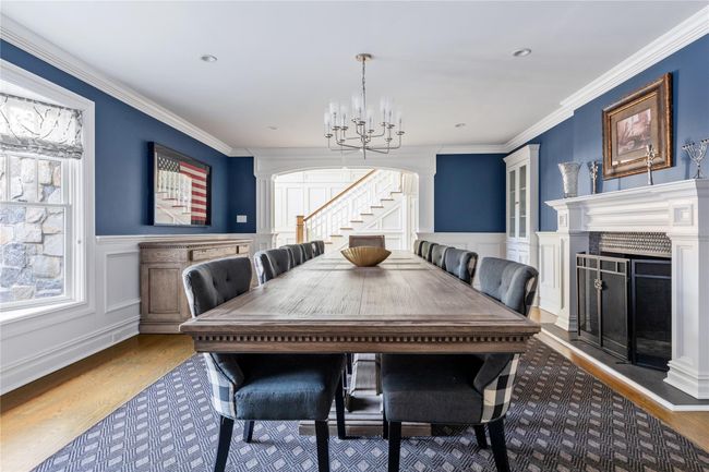 Dining space featuring stairway, a decorative wall, a notable chandelier, and wood finished floors | Image 23