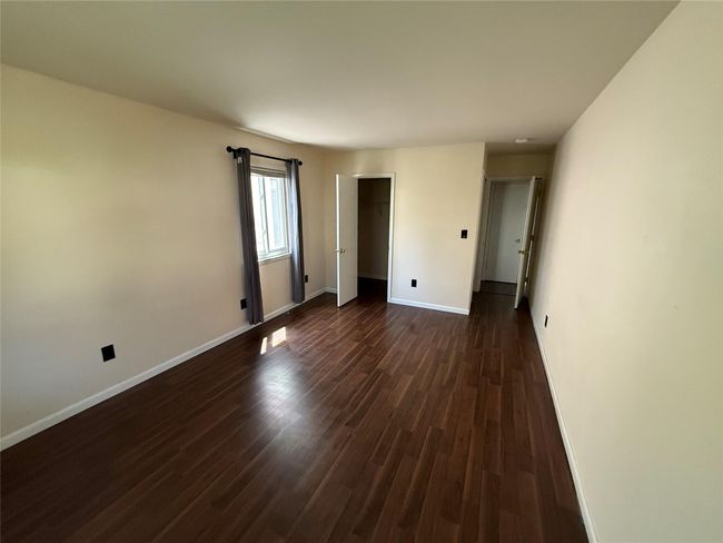 Empty room with dark wood finished floors and baseboards | Image 14