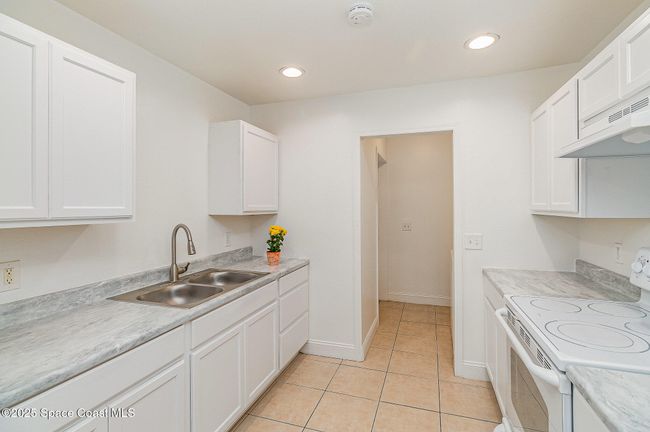 Fully updated kitchen comes with plenty of cabinetry and newer appliances. Door in the middle leads to laundry area. | Image 10