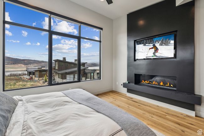 Bedroom with a fireplace, wood finished floors, a water view, and baseboards | Image 18