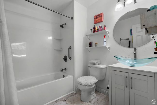 Full bathroom with shower / bath combination with curtain, marble look tiles, and vanity | Image 15