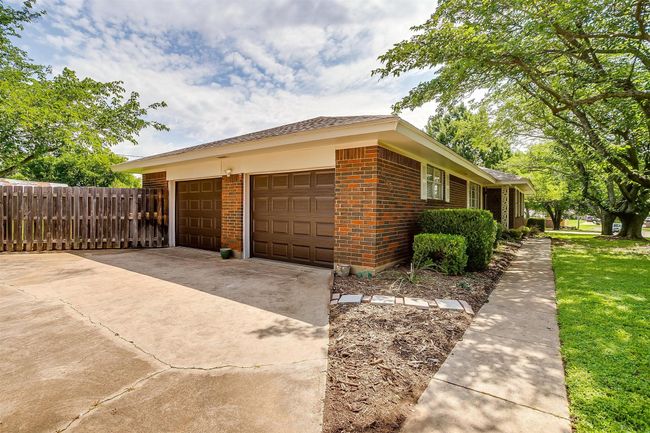 View of home's exterior featuring brick siding, concrete driveway, and a garage | Image 5