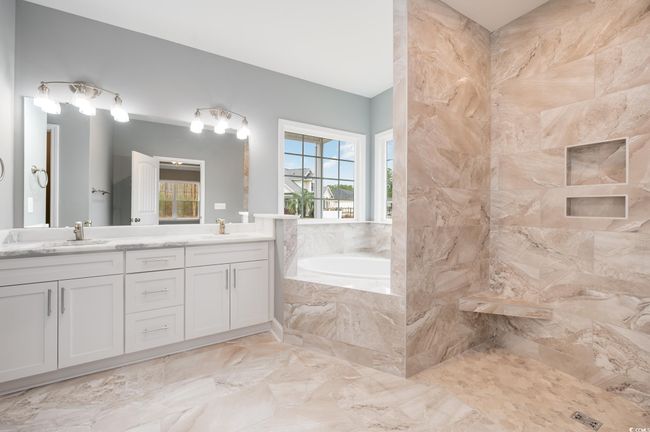 Bathroom featuring a relaxing tiled tub and vanity | Image 19