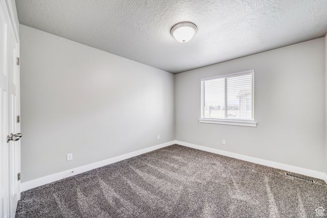 Carpeted spare room featuring baseboards, visible vents, and a textured ceiling | Image 14