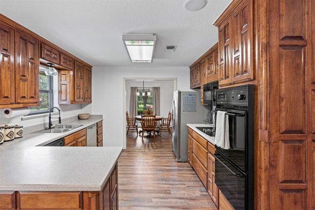 Kitchen featuring light countertops, healthy amount of natural light, and brown cabinets | Image 10
