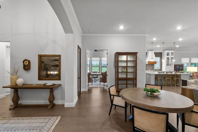Dining space offering ornamental molding, arched walkways, wood floors, and recessed lighting | Image 25