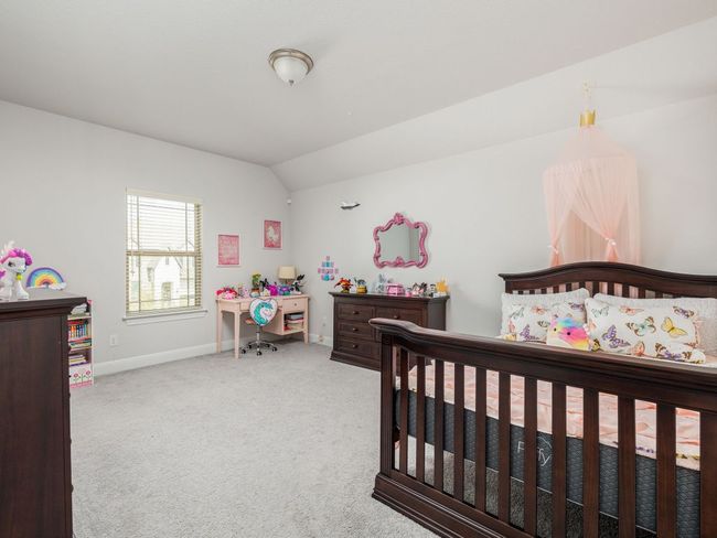 Carpeted bedroom with baseboards and lofted ceiling | Image 22